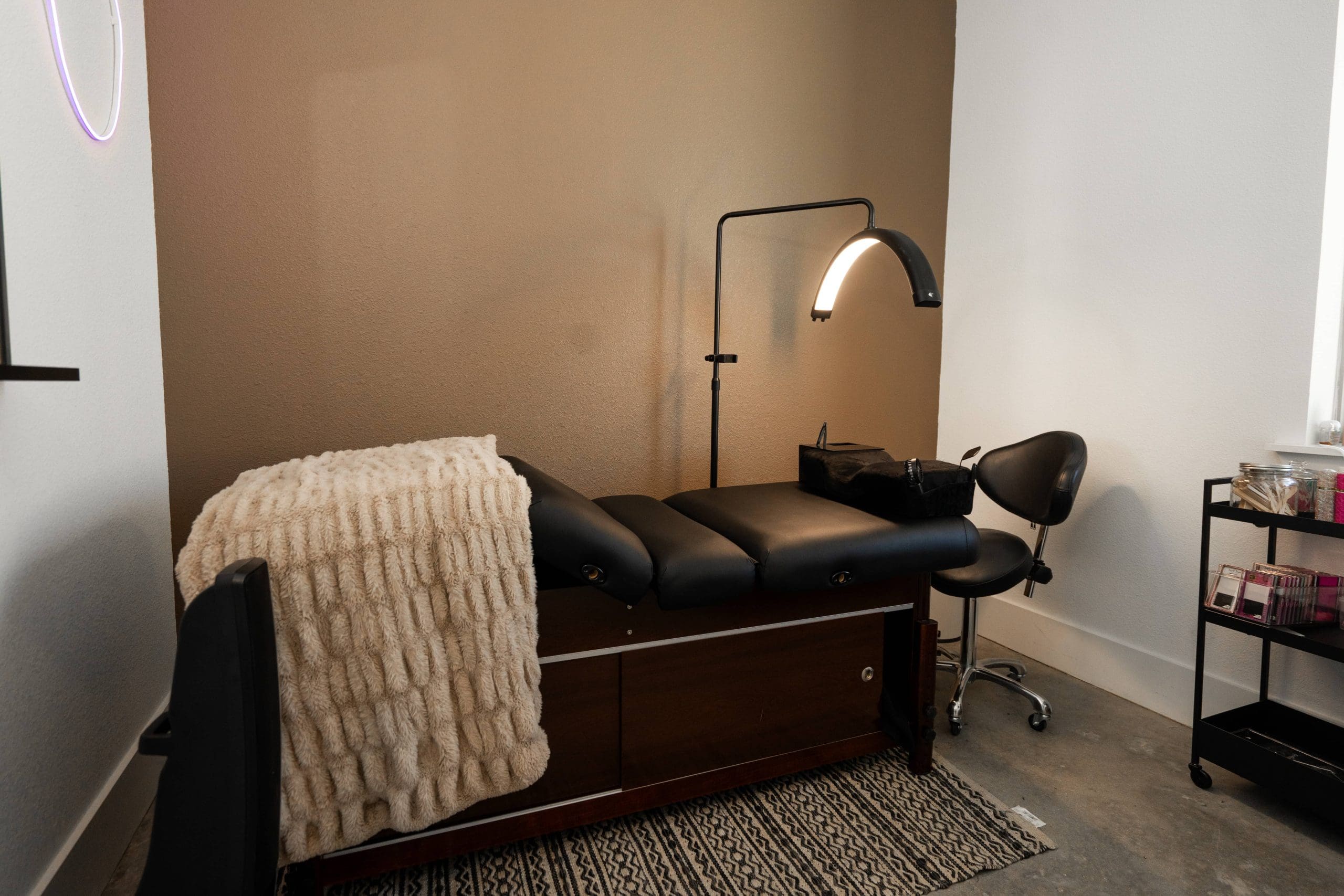A treatment bed with a knitted throw and a ring light