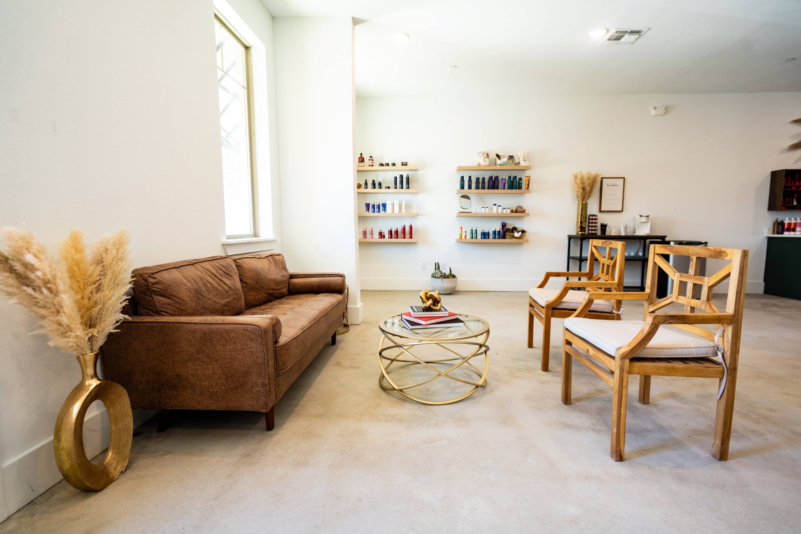 The waiting area: a leather sofa, armchairs and shelves of retail products