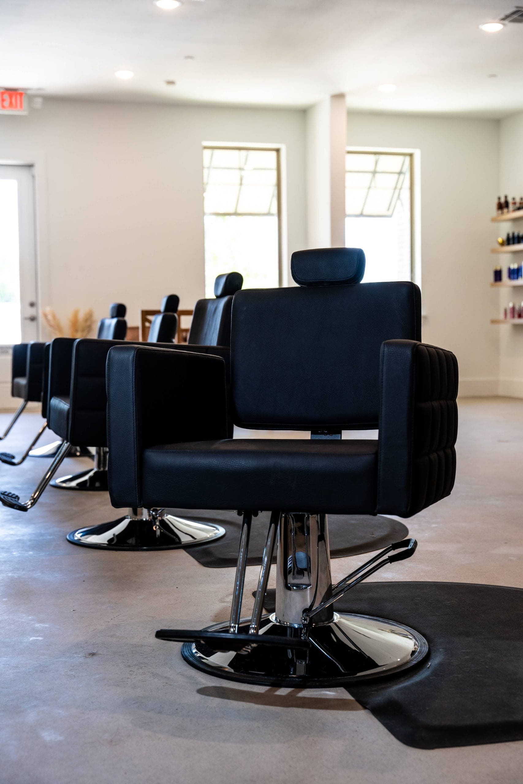 Black styling chairs in a row at Saint Beauty Bar